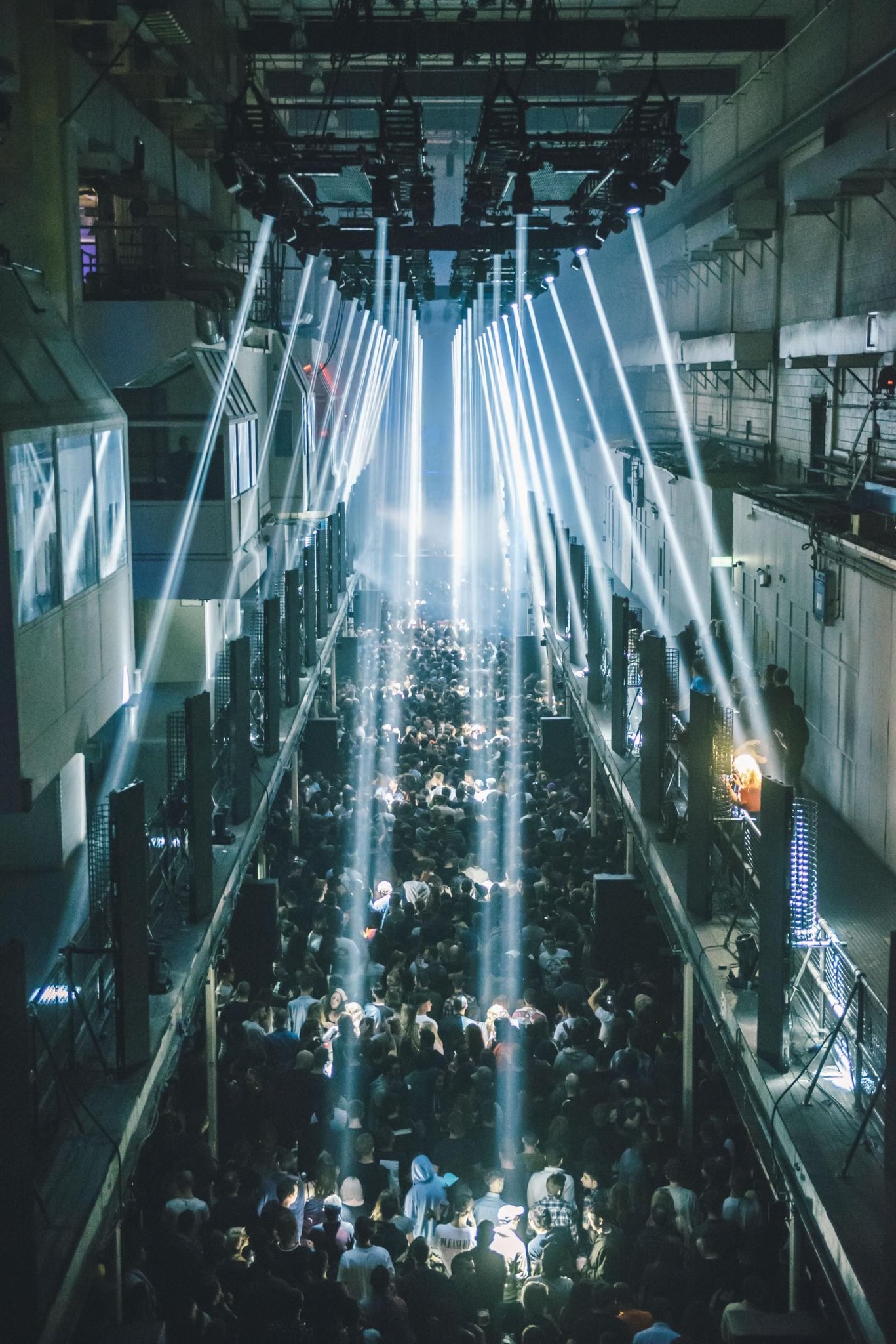 Dark industrial techno club interior with glowing stage lights